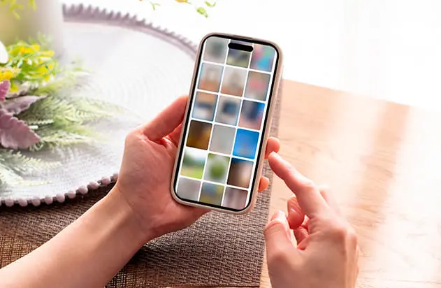 スマートフォンの画面に並んだ複数の画像を指で操作している様子